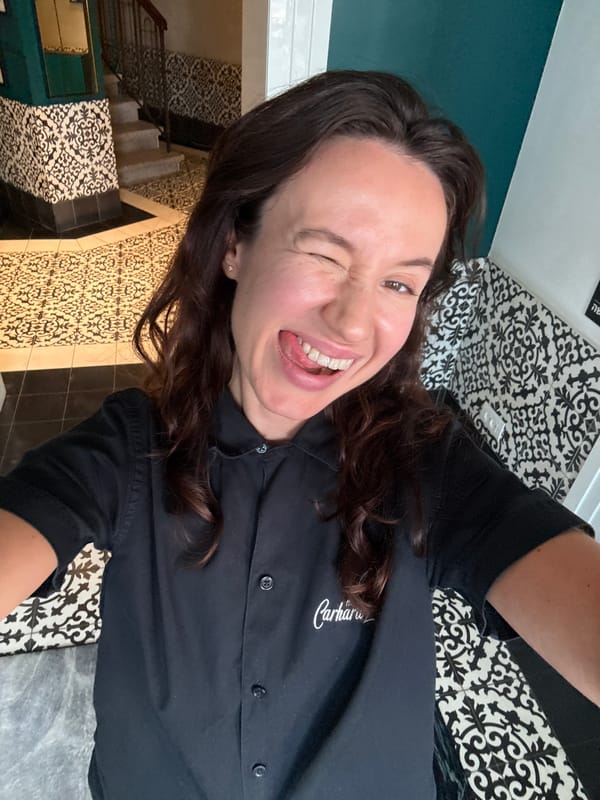 Back-to-back indoor selfies in Tel Aviv, branded work shirts