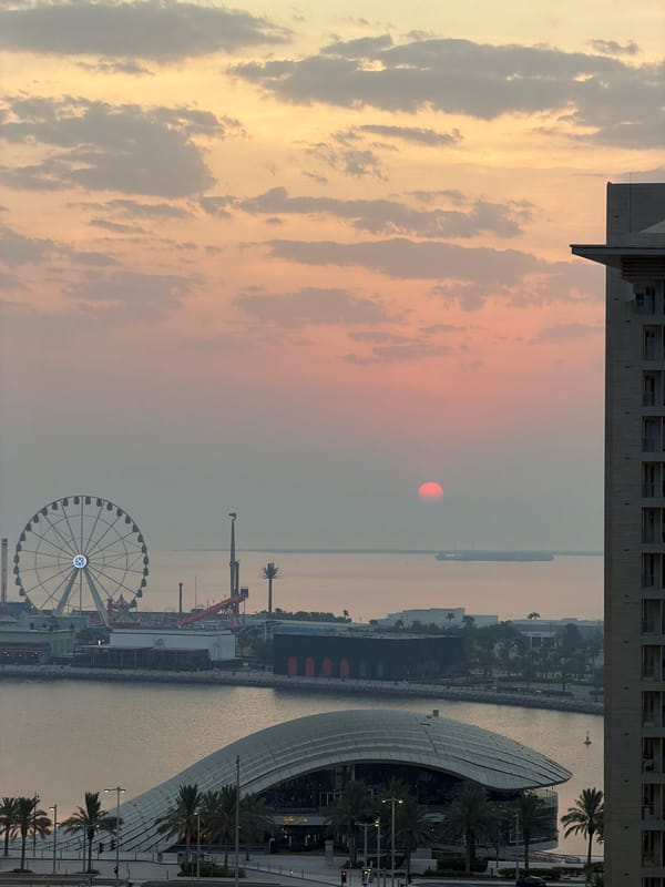 Lusail waterfront at sunrise, Ferris wheel and Gulf skyline.