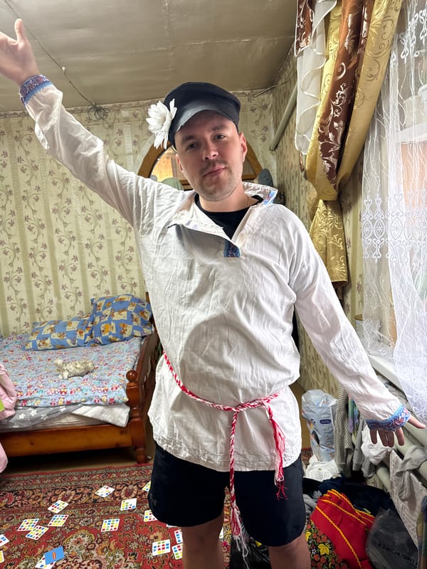 Person stands arms outstretched in cluttered room