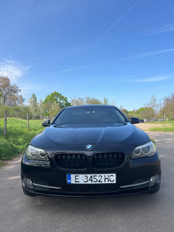 Bulgarian BMW parked on rural road amid greenery