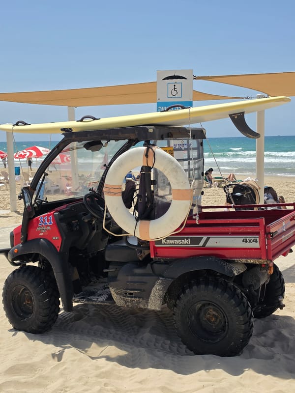 Utility vehicle with surfboard spotted on sunny Bat Yam beach