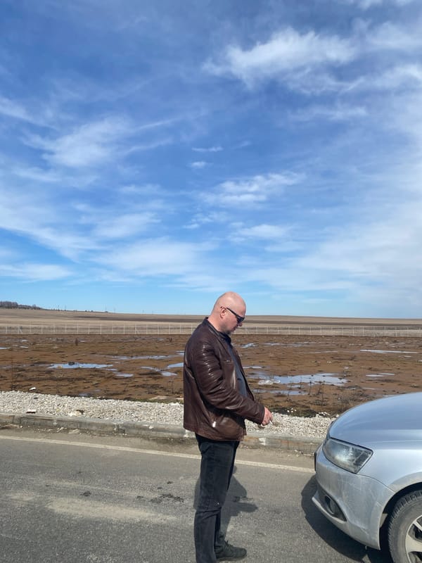 Man in leather jacket stops beside car in rural Russia