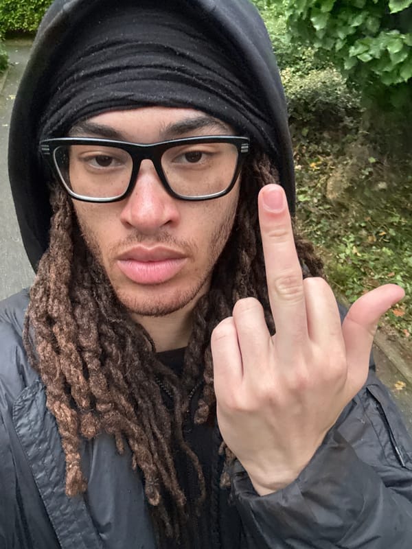 Person with dreadlocks photographed gesturing in Les Ulis park
