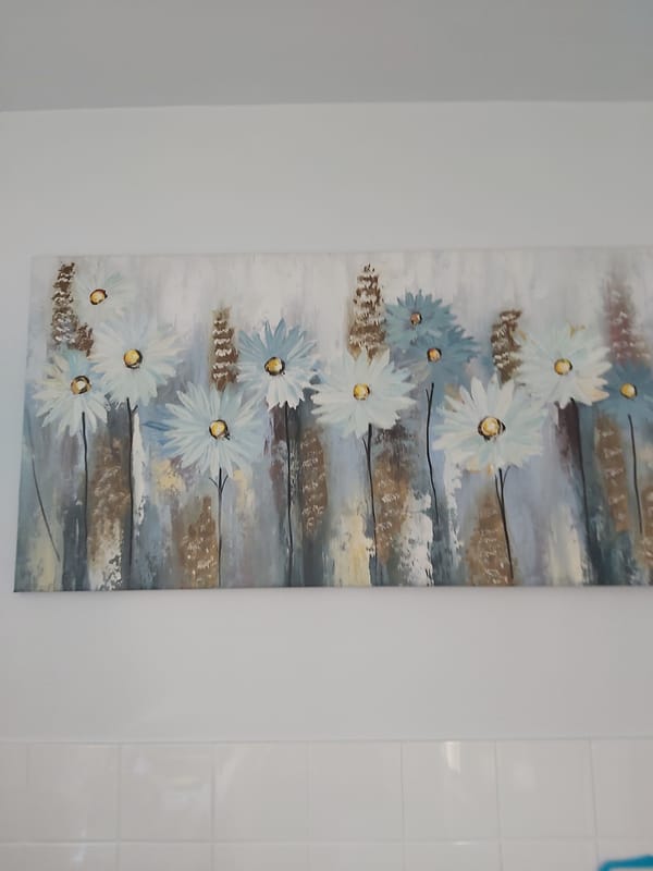 Quiet details of a home interior: art, remote, and flowers