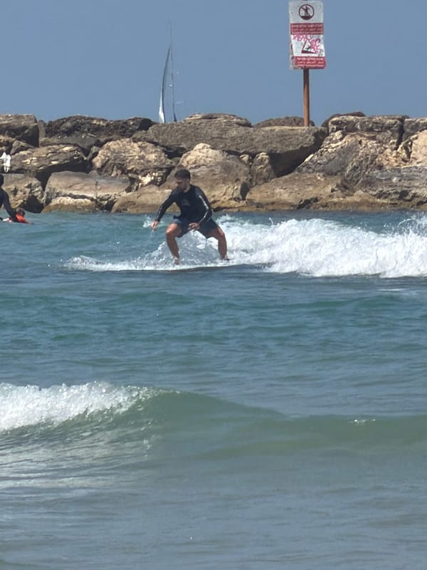 Surfer rides waves near Tel Aviv breakwater