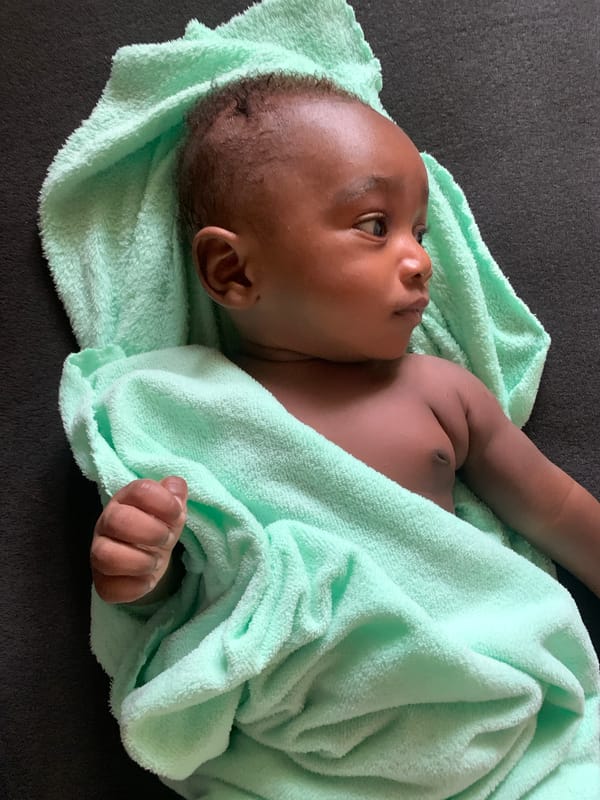 Baby photographed wrapped in green towel in Nigeria