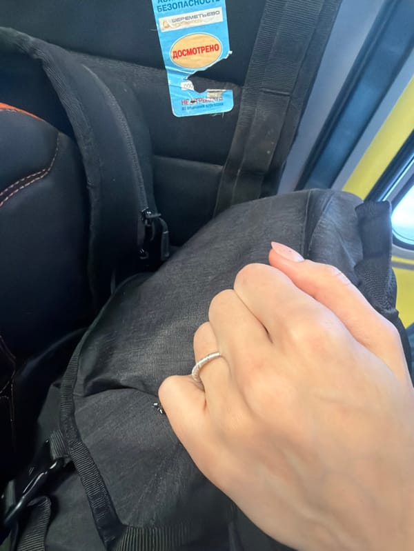 Traveler's hand on tagged backpack observed in Otaru