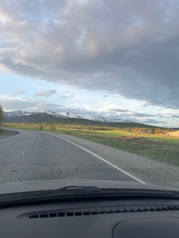 Vehicle travels curving mountain road in Titan, Russia