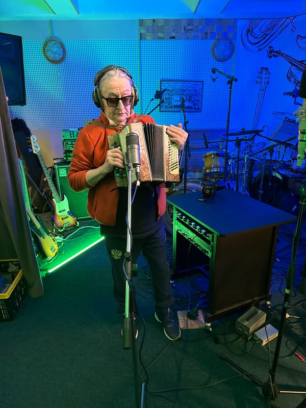Musician plays accordion in green-lit Moscow studio