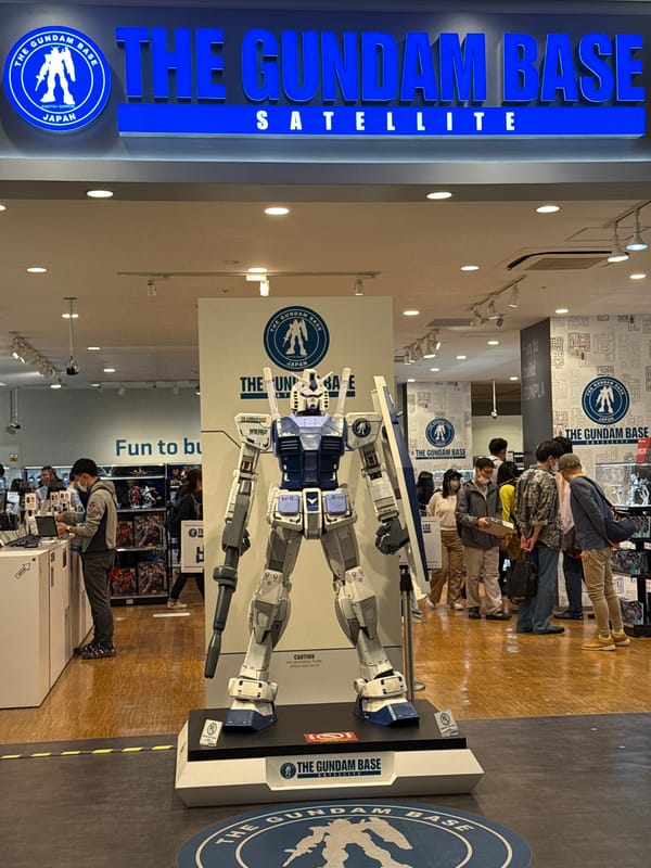 Masked visitors view full-scale Gundam model at Kyoto store