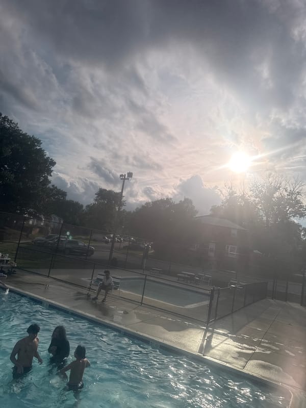 Four people gather at outdoor swimming pool facility