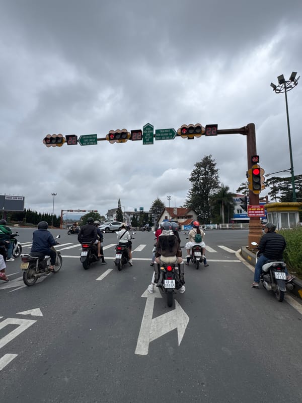 Motorcycle traffic at a Da Lat intersection on a cloudy day