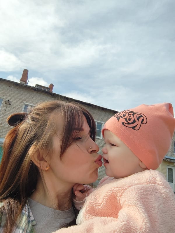 Mother and baby enjoy spring tulip field in Russia