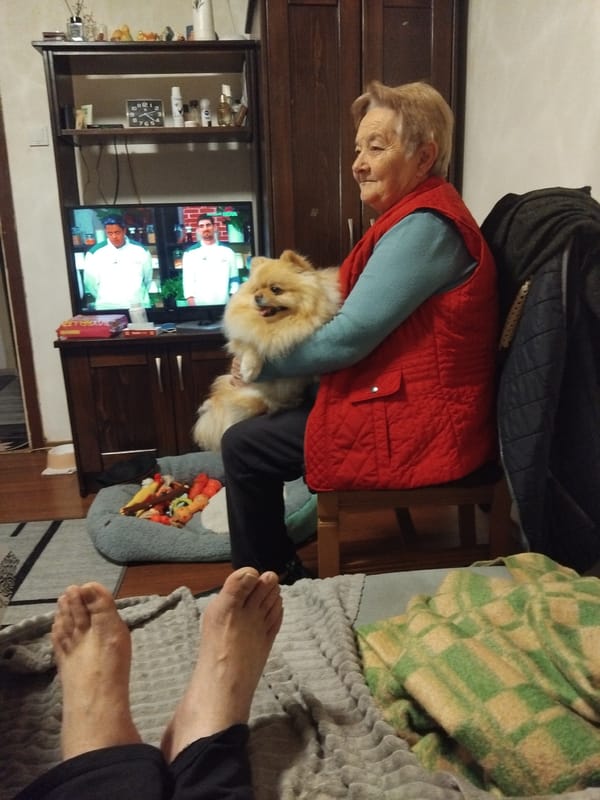 Woman holds Pomeranian dog indoors in Apriltsi