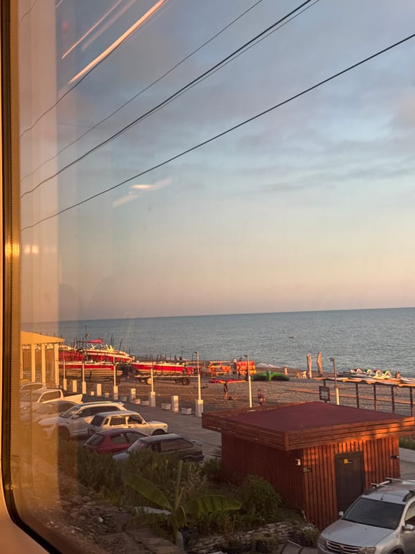 Sochi's Black Sea waterfront at golden hour, seen from land and rail